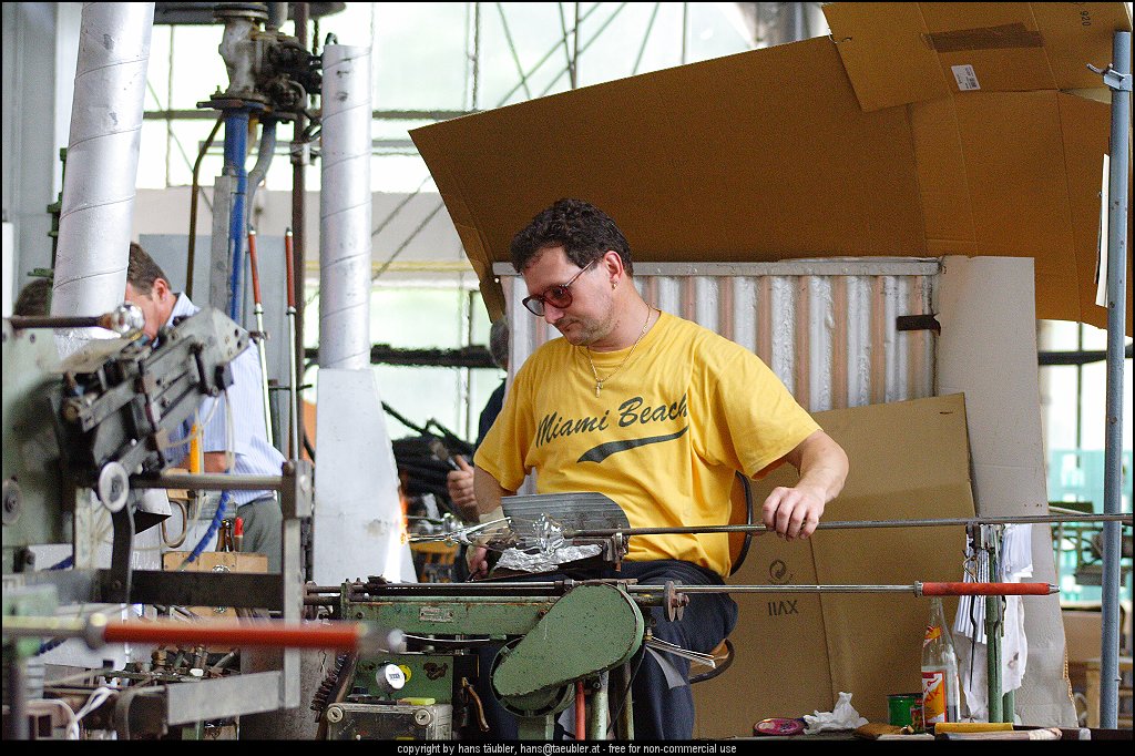 20060809_IMG_glas_26.JPG - Geschick und genaues Arbeiten ist notwendig, um den Glasstiel aus dem noch gl�hend heissen Glas ziehen zu k�nnen - Spiegelau, Bayern
